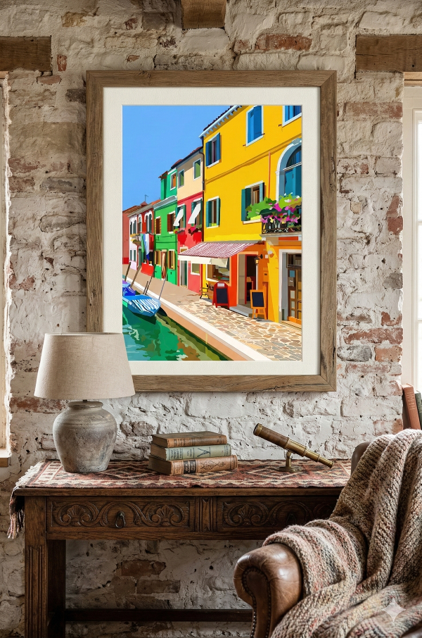 Framed artwork of colorful buildings in a canal scene on a brick wall above a wooden table.