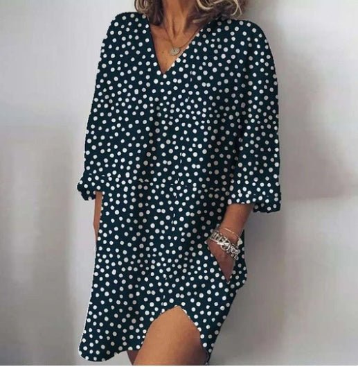 Woman wearing a black polka dot dress against a plain background