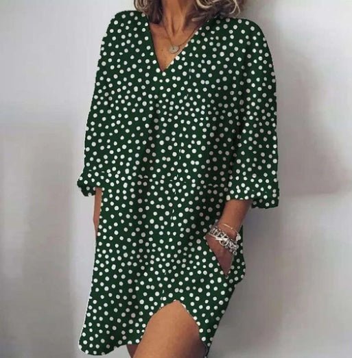 Green polka dot dress worn by a person on a plain background
